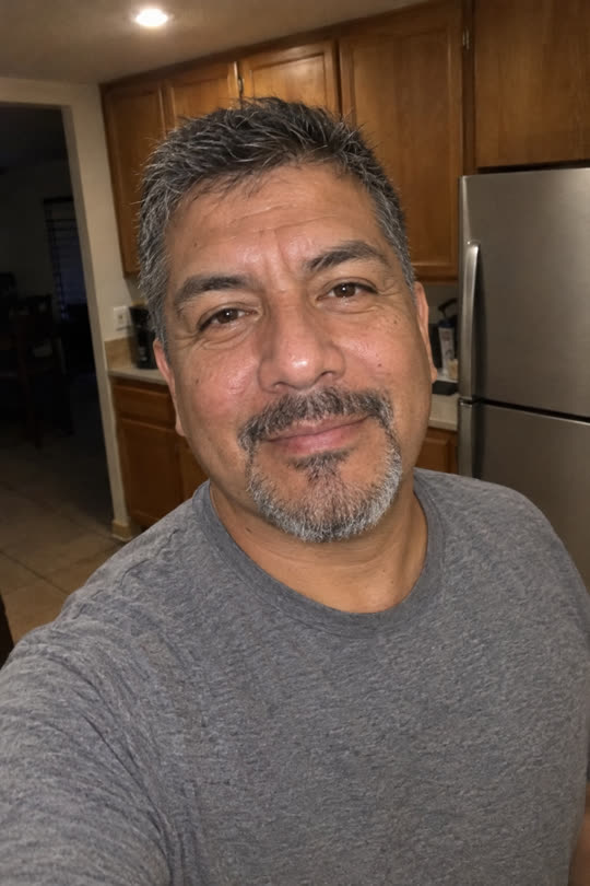 A plain selfie of Ray in his kitchen